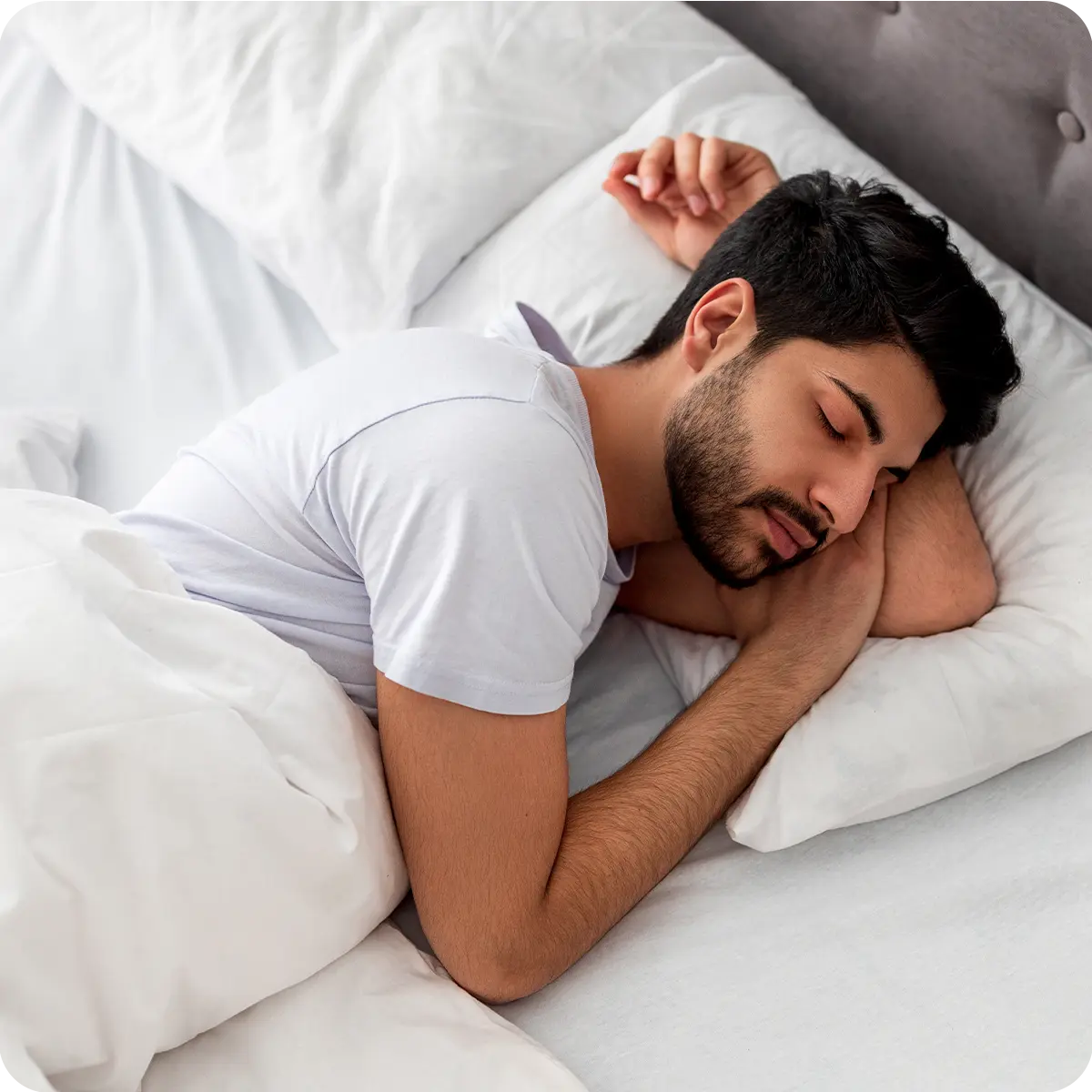 Photo of a man sleeping soundly and relaxed in bed, illustrating the benefit of supporting relaxation and a healthy sleep cycle from the supplement.